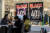 22일(현지시간) 블랙 프라이데이 광고가 붙은 미국의 한 상점 앞에 시민들이 앉아 있는 모습. AFP=연합뉴스