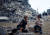 팔레스타인 어린이들이 27일(현지시간) 가자지구 남부 칸 유니스의 파괴된 집터에서 피운 불 앞에 앉아 있다. 로이터=연합뉴스