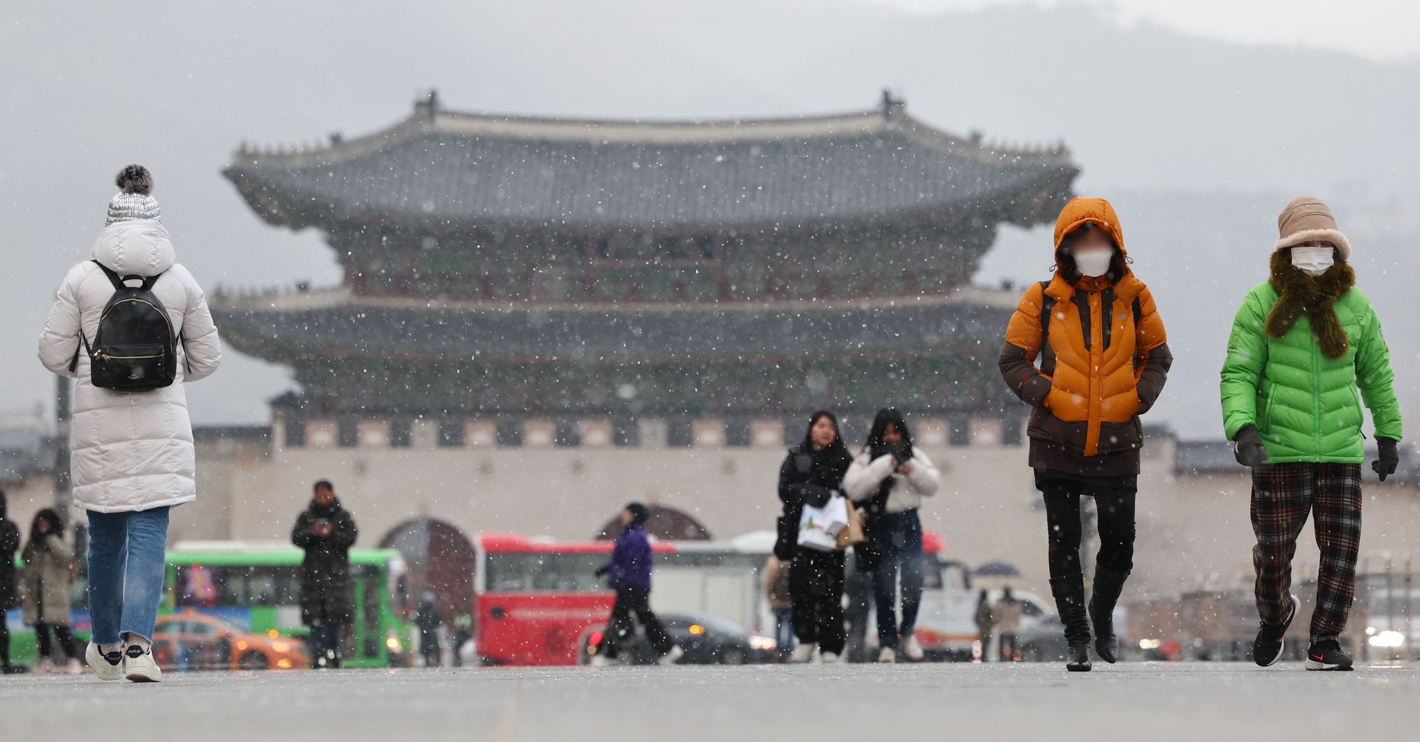 29일 오후 광화문광장에서 시민들이 눈을 맞으며 걸어가고 있다. 연합뉴스