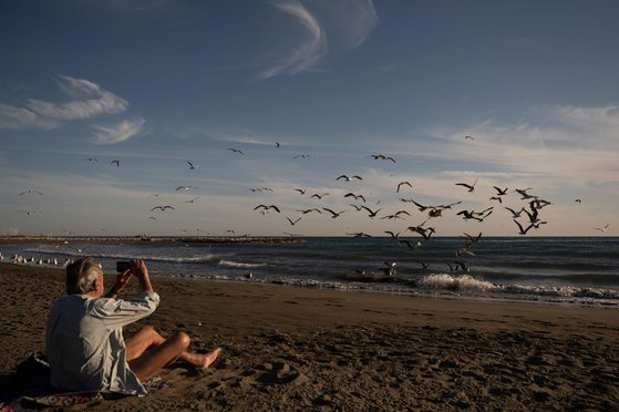 한 남성이 12일 말라가 해변에서 사진을 찍으며 여유를 즐기고 있다. AFP=연합뉴스