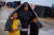 담요를 뒤짚어 쓴 여인과 아이들이 13일 가지지구 남부 라파에서 진흙탕이 된 길을 걷고 있다.로이터=연합뉴스