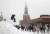 15일(현지시간) 러시아 모스크바에서 폭설이 내리는 동안 한 소년이 눈 덮인 붉은 광장을 걷고 있는 사람들 옆에서 점프를 하고 있다. EPA=연합뉴스