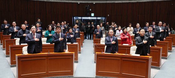 국민의힘 윤재옥 당대표 권한대행을
비롯한 의원들이 15일 오전 국회에서 열린 비상의원총회에서 국기에 경례하고 있다.<br> 연합뉴스