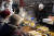 크리스마스를 앞둔 지난 9일(현지시간) 헝가리 부다페스트 바실리카 광장 내 한 크리스마스마켓 상점에서 사람들이 음식을 사고 있다. AP=연합뉴스