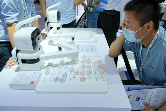 '제7회 세계스마트대회(WIC)' 스마트 과학기술전에서 한 관람객이 지난 5월 18일 인공지능(AI) 장기 로봇과 대결을 펼치고 있다. 신화통신