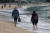 지난 14일 오전 겨울바다를 찾은 관광객과 시민들이 맨발로 부산 해운대해수욕장 해변을 걷고 있다. 송봉근 기자