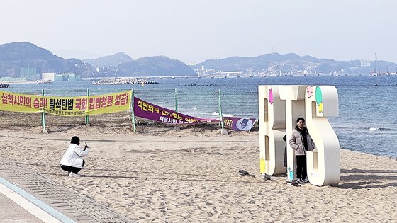 Os turistas estão tirando fotos nas águas cegas de Gangwon Samchung, famoso pelo local do videoclipe do BTS. Porto central