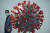 지난 2020년 11월 중국 후베이성 우한에서 열린 제2회 세계보건박람회에서 한 남자가 코로나바이러스 모형 옆을 지나고 있다. AFP=연합뉴스