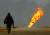 지난해 3월 30일, 이라크 남부 루마일라 유전에서 한 미군 병사가 불타는 유정을 향해 걸어가고 있다. 로이터=연합뉴스 