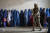 지난해 5월 아프가니스탄 카불에서 여성들이 인도주의적 구호 단체가 배포한 식량 배급을 받기 위해 기다리는 동안 탈레반 전사가 경비를 서고 있다. AP=연합뉴스 