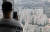서울 송파구 롯데월드 서울스카이 전망대를 찾은 한 시민이 휴대폰으로 잠실 아파트 단지를 휴대폰 사진으로 찍고 있다. 뉴스1
