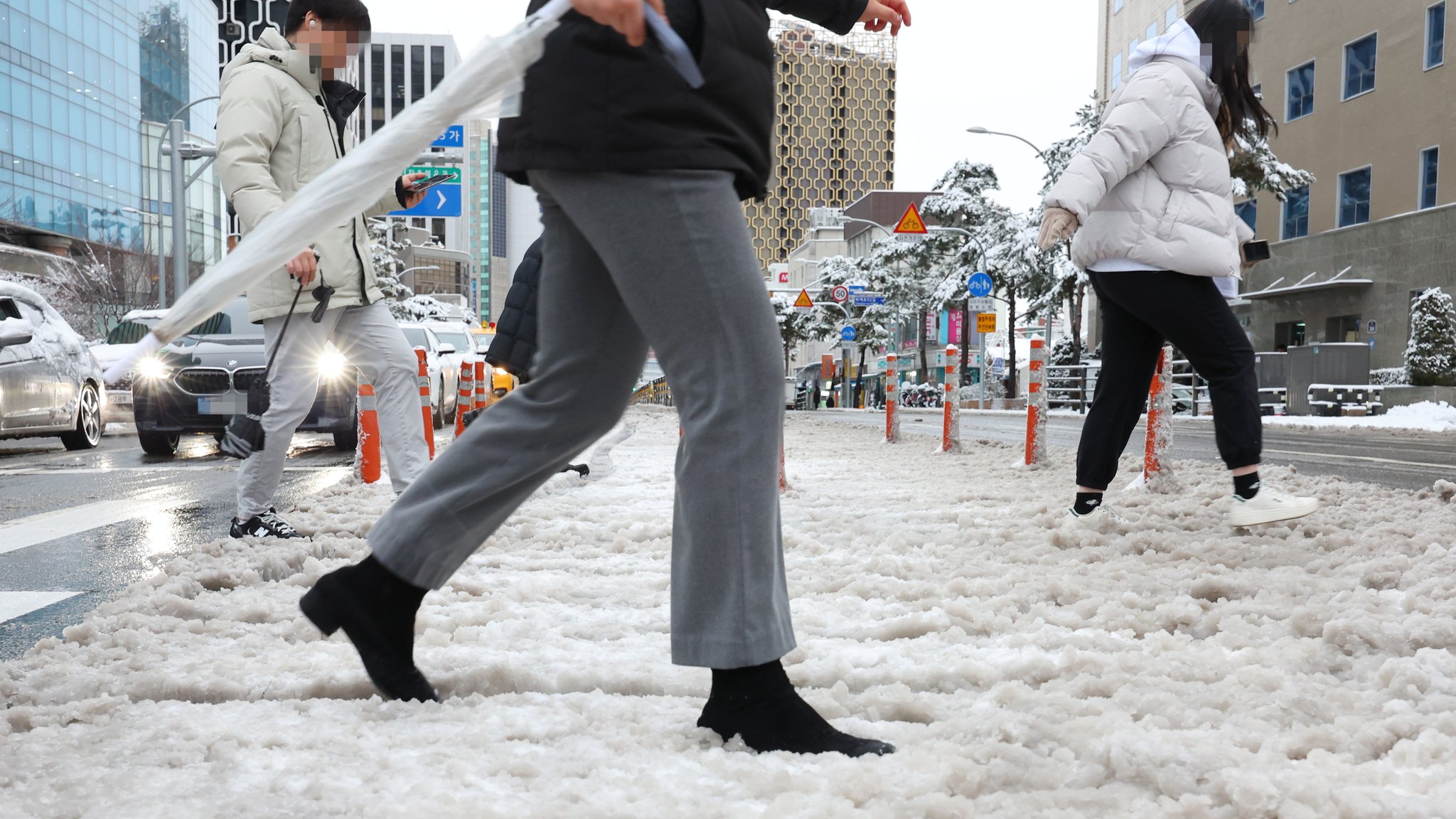 22일 서울 시내 곳곳에서 밤새 내린 눈이 녹아 진창이 되거나 얼어붙어 출근길 시민들이 어려움을 겪고 있다. 뉴시스