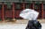 서울 지역에 눈이 내리는 지난달 21일 종로구 경복궁에서 관광객이 망가진 우산을 쓴 채 걸어가고 있다. 뉴스1