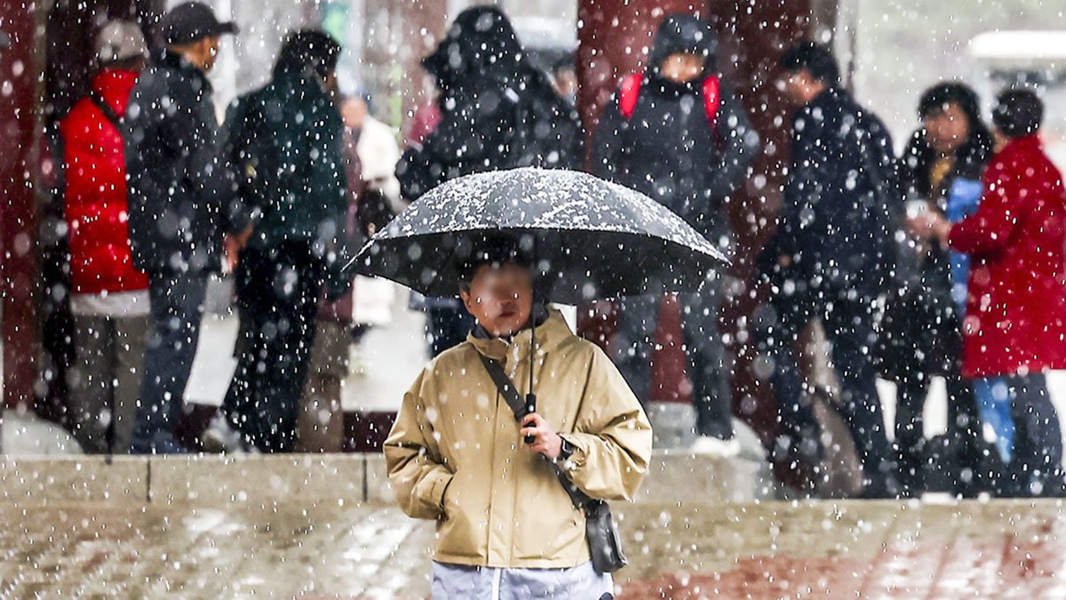 서울 지역에 눈이 내린 7일 서울 중구 남산골한옥마을에 한 시민이 우산을 쓰고 이동하고 있다. 
