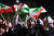 14일(현지시간) 이란 테헤란의 영국 대사관 앞에서 시위대가 이란과 팔레스타인 국기를 흔들며 시위를 벌이고 있다. AFP=연합뉴스