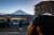 지난 1월 한 관광객이 후지산이 보이는 편의점 앞에서 사진을 찍고 있는 모습. AFP=연합뉴스