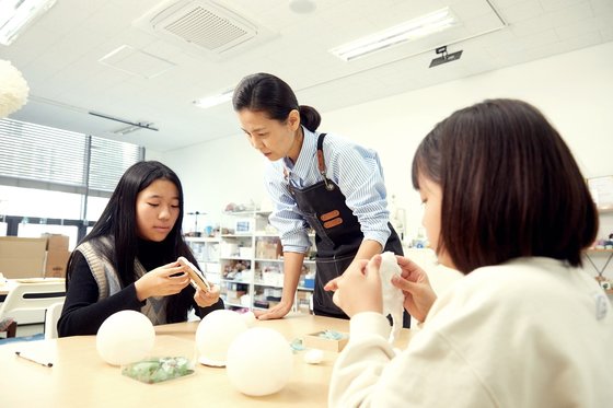 Instructor Wang Young-sil (center) explained the concept and method of beachcombing and beachcombing upcycling to the student reporters. 