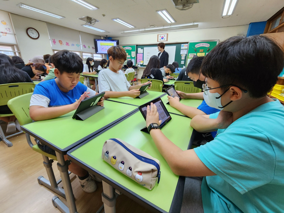 지난 12일 경기도 디지털교육 선도학교로 지정된 김포 솔터초등학교 6학년 학생들이 태블릿 PC를 이용해 영어 수업에 참여하고 있다. 유길용 기자